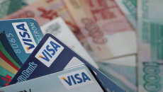 Пластиковые карты Visa и денежные купюры достоинством 1000 и 5000 рублей. Архивное фото Пластиковые карты Visa и денежные купюры достоинством 1000 и 5000 рублей. Архивное фото