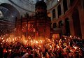 Верующие во время схождения Благодатного огня в храме Гроба Господня в Иерусалиме Верующие во время схождения Благодатного огня в храме Гроба Господня в Иерусалиме