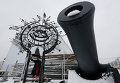 Экскурсовод показывает старинный колокол на территории верфи исторического судостроения в поселке Лахта Экскурсовод показывает старинный колокол на территории верфи исторического судостроения в поселке Лахта