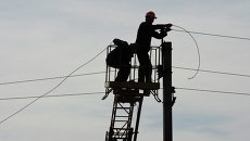 Рабочие восстанавливают линию электропередач в Донецкой области. Архивное фото Рабочие восстанавливают линию электропередач в Донецкой области. Архивное фото