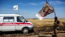Украинский военный с белым флагом во время передачи убитых на нейтральной территории вблизи поселка Диброво возле российско-украинской границы в Донецкой области Украинский военный с белым флагом во время передачи убитых на нейтральной территории вблизи поселка Диброво возле российско-украинской границы в Донецкой области