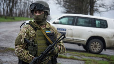 Украинский военный возле машины наблюдателей ОБСЕ возле деревни Широкино. Архивное фото Украинский военный возле машины наблюдателей ОБСЕ возле деревни Широкино. Архивное фото