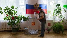 Житель села на избирательном участке. Архивное фото Житель села на избирательном участке. Архивное фото