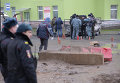 Представители правоохранительных органов осматривают место происшествия с полицейской машиной Представители правоохранительных органов осматривают место происшествия с полицейской машиной