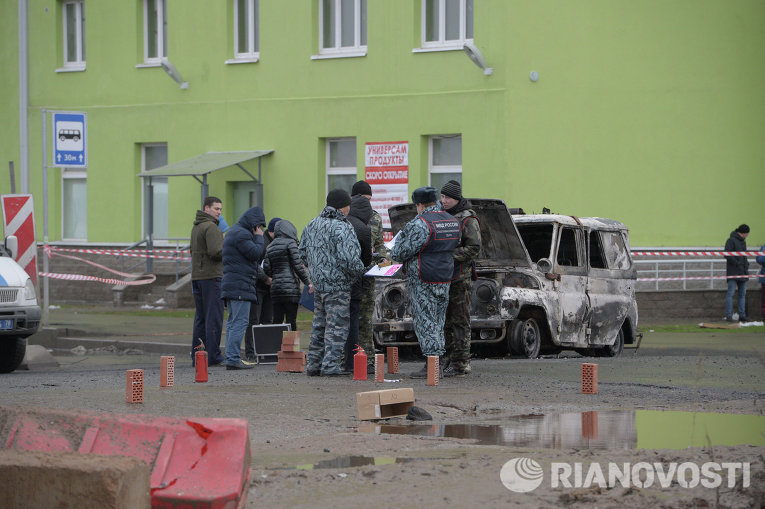 Представители правоохранительных органов осматривают место происшествия с полицейской машиной Представители правоохранительных органов осматривают место происшествия с полицейской машиной