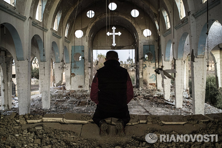 Житель одной из деревень в провинции Эль-Хасаке на северо-востоке Сирии молится в храме Святого Георгия, уничтоженного боевиками ИГ (ДАИШ) Житель одной из деревень в провинции Эль-Хасаке на северо-востоке Сирии молится в храме Святого Георгия, уничтоженного боевиками ИГ (ДАИШ)