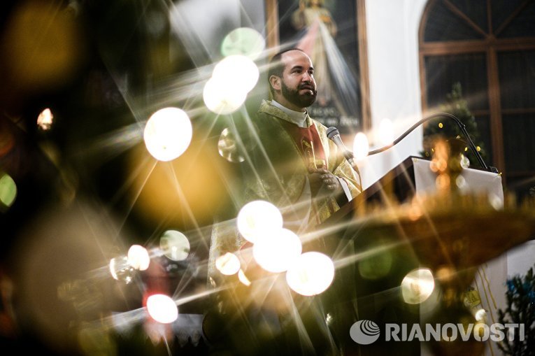 Священнослужитель во время празднования католического Рождества в Храме Святых Апостолов Петра и Павла в Великом Новгороде Священнослужитель во время празднования католического Рождества в Храме Святых Апостолов Петра и Павла в Великом Новгороде