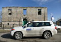 Автомобиль ОБСЕ у разрушенного дома в поселке Зайцево в Донецкой области Автомобиль ОБСЕ у разрушенного дома в поселке Зайцево в Донецкой области