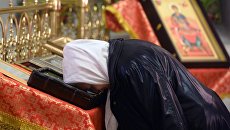 Прихожанка во время пасхальной службы в церкви. Архивное фото Прихожанка во время пасхальной службы в церкви. Архивное фото