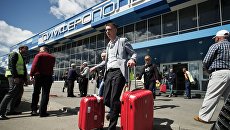 Туристы, прибывшие на отдых в Крым, выходят из здания международного аэропорта Симферополь Туристы, прибывшие на отдых в Крым, выходят из здания международного аэропорта Симферополь