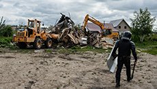 Сотрудник правоохранительных органов в поселке Плеханово в Тульской области, где происходит снос незаконно установленных построек. Архивное фото Сотрудник правоохранительных органов в поселке Плеханово в Тульской области, где происходит снос незаконно установленных построек. Архивное фото