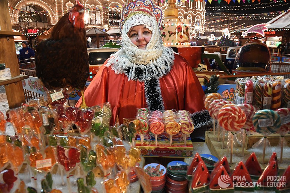 Продавщица леденцов на традиционной новогодней ГУМ-Ярмарке рядом с ГУМ-Катком на Красной площади в Москве Продавщица леденцов на традиционной новогодней ГУМ-Ярмарке рядом с ГУМ-Катком на Красной площади в Москве