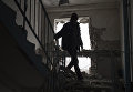 Местный житель в поврежденном в результате обстрелов здании в Киевском районе Донецка Местный житель в поврежденном в результате обстрелов здании в Киевском районе Донецка