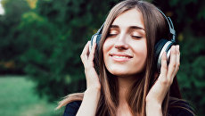 Girl listening to music on headphones.  Archival photo