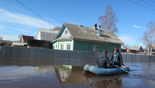 Люди на резиновой лодке во время паводка. Архивное фото