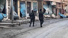 Солдаты у разрушенных в результате боевых действий домов в жилой части города Пальмира. Архивное фото Солдаты у разрушенных в результате боевых действий домов в жилой части города Пальмира. Архивное фото
