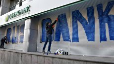 Участники акции у входа в центральное отделение дочернего предприятия Сбербанка России в Киеве. 13 марта 2017 Участники акции у входа в центральное отделение дочернего предприятия Сбербанка России в Киеве. 13 марта 2017