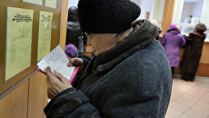 Женщина проверяет правильность заполнения квитанций об оплате коммунальных услуг Женщина проверяет правильность заполнения квитанций об оплате коммунальных услуг