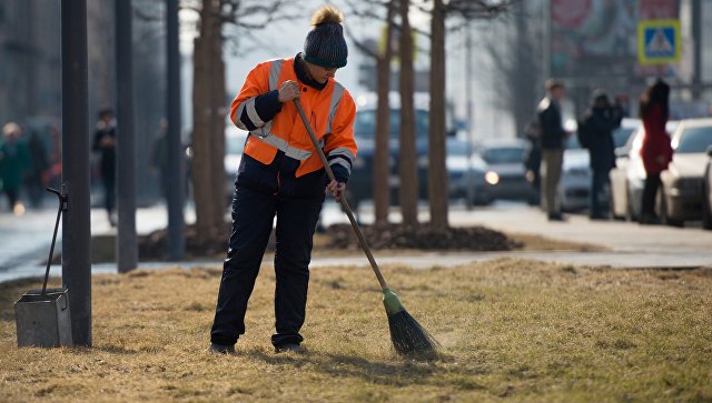 Работник коммунальных служб убирает улицу в Москве