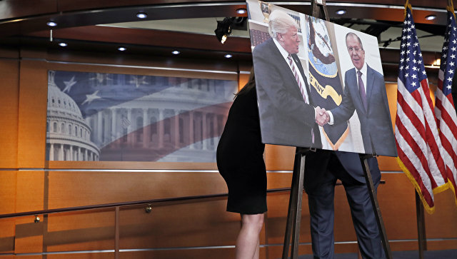 Переговоры за картиной с изображением встречи президента США Дональда Трампа и главы МИД России Сергея Лаврова в Конгрессе США