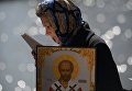 Верующая стоит в очереди к храму Христа Спасителя, где находится ковчег с мощами святителя Николая Чудотворца Верующая стоит в очереди к храму Христа Спасителя, где находится ковчег с мощами святителя Николая Чудотворца