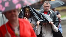 Прохожие во время дождя в Москве. Архивное фото Прохожие во время дождя в Москве. Архивное фото