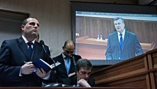 Виктор Янукович во время видеотрансляции на экране монитора в Святошинском районном суде Киева. Архивное фото Виктор Янукович во время видеотрансляции на экране монитора в Святошинском районном суде Киева. Архивное фото