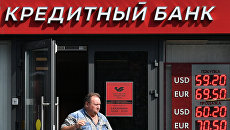 Мужчина выходит из отделения Московского кредитного банка. Архивное фото Мужчина выходит из отделения Московского кредитного банка. Архивное фото