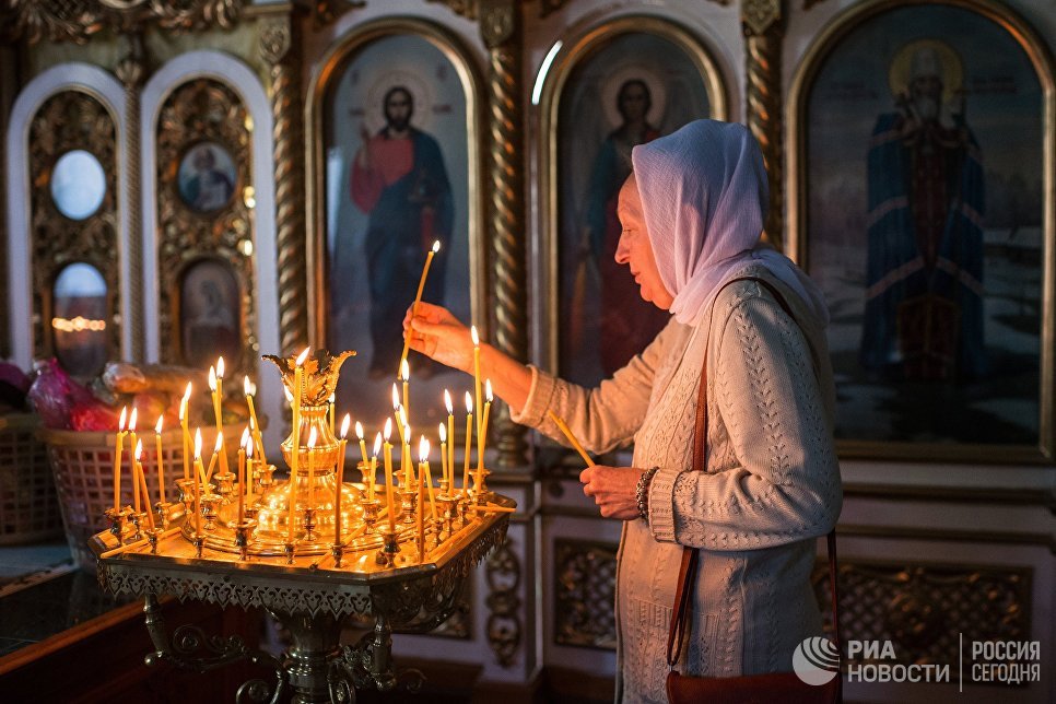 Женщина во время богослужения в честь праздника Преображения Господня в соборе Воздвижения Креста Господня в Омске. 19 августа 2017 Женщина во время богослужения в честь праздника Преображения Господня в соборе Воздвижения Креста Господня в Омске. 19 августа 2017