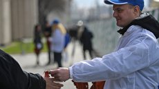 Волонтер раздает георгиевские ленточки. Архивное фото Волонтер раздает георгиевские ленточки. Архивное фото