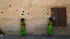 Сирийские девочки позируют фотографу на фоне изрешеченной пулями стены в деревне Кафр Гхан к северу от Алеппо Сирийские девочки позируют фотографу на фоне изрешеченной пулями стены в деревне Кафр Гхан к северу от Алеппо