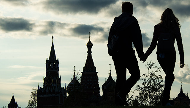 Москвичи на фоне Спасской башни Московского Кремля