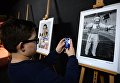 Посетитель фотографирует на фотовыставке МИА Россия сегодня в рамках премьеры фильма Салют-7 в кинотеатре Октябрь Посетитель фотографирует на фотовыставке МИА Россия сегодня в рамках премьеры фильма Салют-7 в кинотеатре Октябрь