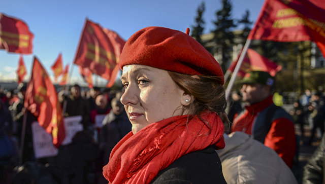 Участница митинга в честь 100-летия Великой Октябрьской социалистической революции у Финляндского вокзала в Санкт-Петербурге. 7 ноября 2017