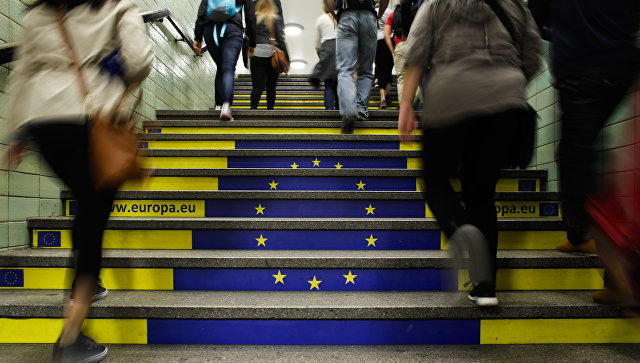 Пассажиры метро поднимаются по лестнице с изображением флага Евросоюза в Берлине