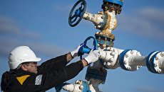 Рабочий на нефтяном месторождении. Архивное фото Рабочий на нефтяном месторождении. Архивное фото