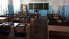 Преподаватель в школьном кабинете. Архивное фото Преподаватель в школьном кабинете. Архивное фото