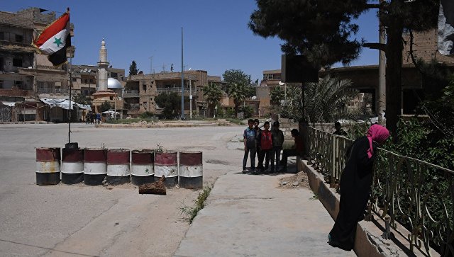 Жители на улице в сирийском городе Дейр-эз-Зор