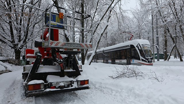 Машина электриков ремонтной бригады устраняющих последствия падения дерева на провода трамвайных путей из-за снегопада в Москве. 4 феврал