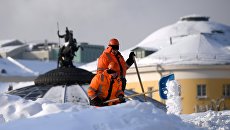 Сотрудники коммунальных служб убирают снег на Манежной площади в Москве Сотрудники коммунальных служб убирают снег на Манежной площади в Москве