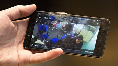 Человек смотрит на смартфоне трансляцию с камер наблюдения редакции газеты Вести, где проходят обыски. 8 февраля 2018 Человек смотрит на смартфоне трансляцию с камер наблюдения редакции газеты Вести, где проходят обыски. 8 февраля 2018