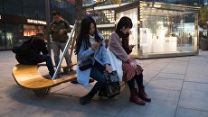 Горожане на территории многофункционального комплекса Sanlitun Soho в Пекине. Архивное фото Горожане на территории многофункционального комплекса Sanlitun Soho в Пекине. Архивное фото