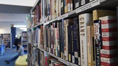 Книги на полках в библиотеке. Архивное фото Книги на полках в библиотеке. Архивное фото