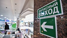 Указатель и знак Запасный выход в торгово-развлекательном центре. Архивное фото Указатель и знак Запасный выход в торгово-развлекательном центре. Архивное фото