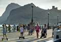Отдыхающие прогуливаются по набережной в Судаке Отдыхающие прогуливаются по набережной в Судаке
