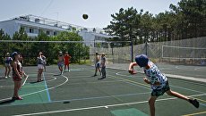 Дети играют в пионербол на спортивной площадке детского оздоровительного лагеря Бригантина в поселке Песчаное в Крыму Дети играют в пионербол на спортивной площадке детского оздоровительного лагеря Бригантина в поселке Песчаное в Крыму