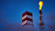 Буровая вышка и газовый факел морской нефтеперерабатывающей платформы Буровая вышка и газовый факел морской нефтеперерабатывающей платформы