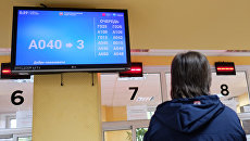 Посетитель у табло электронной очереди в отделении ГИБДД. Архивное фото Посетитель у табло электронной очереди в отделении ГИБДД. Архивное фото