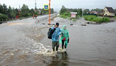Местные жители на затопленной в результате паводка улице в Чите. 11 июля 2018 Местные жители на затопленной в результате паводка улице в Чите. 11 июля 2018