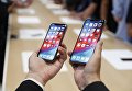 Человек держит новый Apple iPhone XS и XS Max. 12 сентября 2018 года Человек держит новый Apple iPhone XS и XS Max. 12 сентября 2018 года